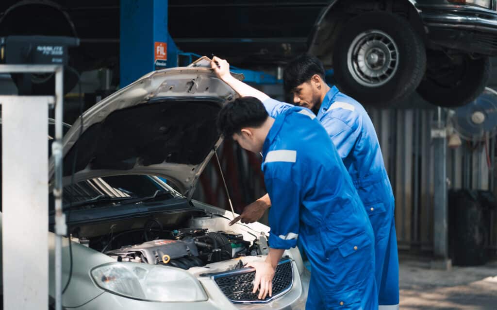 two mechanincs working with car diagnostics tool